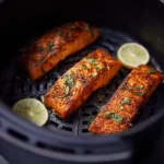 Delicious air-fried salmon fillet garnished with parsley and lemon slices.