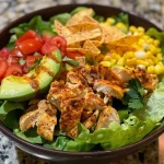 Juicy Santa Fe Salad filled with chicken, tomatoes, and tortilla chips on a plate.