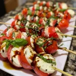 Juicy Caprese skewers with thick slices of tomatoes and mozzarella cheese, garnished with basil.