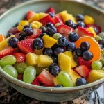 Bright, fresh fruit salad filled with juicy strawberries, blueberries, and diced mango arranged attractively.