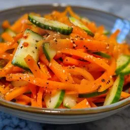 Colorful Carrot Cucumber Salad featuring grated carrots and cucumbers, plated appetizingly.