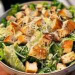 Detailed photograph of a Classic Caesar Salad with vibrant greens and golden croutons.