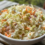 Juicy, creamy coleslaw featuring shredded cabbage and a glossy dressing, taken with an iPhone.