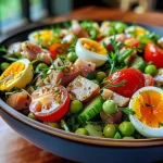 A beautifully arranged Salade Nicoise, showcasing its fresh vegetables and tuna.