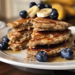 Close-up view of Blueberry Banana Oat Pancakes stacked on a plate.