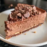 Rich No Bake Chocolate Cheesecake decorated with chocolate ganache and a sprinkle of cocoa powder.