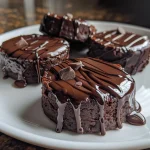 Close-up view of a One-Bite Mini Chocolate Fudge Cake with a shiny chocolate glaze.