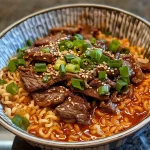 Close-up view of a bowl of Spicy Korean Ramen topped with grilled beef and creamy sauce.
