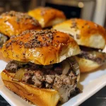 Juicy beef sliders on slider buns with toppings.