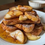 Close-up side view of a delicious slice of Apple Cinnamon French Toast topped with diced apples and cinnamon.
