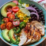 Close-up of a delicious chicken taco rice bowl with colorful toppings.