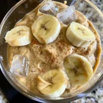 ['Close-up view of a creamy banana almond butter smoothie in a glass.', 'Side view of a delicious banana almond butter smoothie with a yellow banana slice.', 'Smoothie made with banana and almond butter, topped with ground cinnamon.', 'Refreshing energy booster smoothie featuring banana and almond butter in a clear glass.']