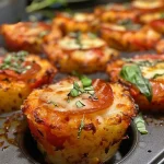 ['Close-up of Crunchy Pizza Potato Cups topped with pepperoni and fresh basil.', 'Side view of delicious Crunchy Pizza Potato Cups with melted cheese and sauce.', 'Juicy Crunchy Pizza Potato Cups arranged in a muffin tray with Italian seasoning.', 'Tasty Crunchy Pizza Potato Cups showcasing a golden exterior with pizza toppings.']