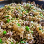 ['Close-up view of a Garlic Butter Beef Rice Skillet with visible rice, peas, and beef.', 'Juicy Garlic Butter Beef Rice Skillet featuring brown ground beef, white rice, and green peas.', 'Side view of a flavorful Garlic Butter Beef Rice Skillet garnished with parsley.', 'Close-up of a hearty meal, showcasing beef, rice, and garlic butter in a skillet.']