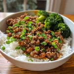 ['A close-up side view of a Ground Beef Hot Honey Bowl with steam rising, showcasing juicy beef and colorful vegetables.', 'A vibrant Ground Beef Hot Honey Bowl featuring minced beef, green onions, and sesame seeds on a bed of fluffy rice.', 'A detailed view of a hearty Ground Beef Hot Honey Bowl garnished with fresh cilantro and colorful sautéed peppers.', 'An appetizing Ground Beef Hot Honey Bowl displaying ground beef, hot honey drizzle, and a variety of fresh vegetables.']
