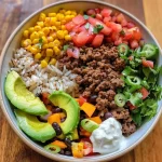 ['Close-up of a Ground Beef Taco Bowl filled with ingredients.', 'Juicy Ground Beef Taco Bowl with vibrant toppings and sweet potatoes.', 'Side view of a colorful Ground Beef Taco Bowl topped with avocado.', 'Detailed shot of a hearty Ground Beef Taco Bowl showcasing fresh ingredients.']