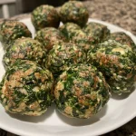 ['Close-up view of golden-brown spinach balls on a white plate.', 'Juicy spinach balls with a crispy exterior, arranged artistically.', 'A side view of spinach balls showcasing their texture and color.', 'Delicious spinach balls garnished on a wooden table.']