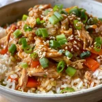 ['Close-up side view of a Teriyaki Chicken and Rice Casserole topped with sesame seeds and sliced green onions.', 'Juicy Teriyaki Chicken and Rice Casserole in a dish, showcasing colorful vegetables and glistening sauce.', 'Serving of Teriyaki Chicken and Rice Casserole with shredded chicken and vibrant vegetables, viewed from the side.', 'Delicious Teriyaki Chicken and Rice Casserole displaying a mix of rice, chicken, and garnishing ingredients.']