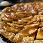 ['Close-up view of a golden Apple Galette drizzled with salted caramel.', 'Side view of a delicious Apple Galette with a glossy caramel topping.', 'Juicy apple-filled galette with a rich salted caramel glaze on a plate.', 'Homemade Apple Galette showcasing sliced apples and a sweet caramel drizzle.']