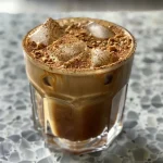 ['Close-up side view of a Brown Sugar Shaken Espresso in a clear glass, showcasing its layers and color.', 'Detailed view of a glass filled with Brown Sugar Shaken Espresso, highlighting the ice cubes and creamy texture.', 'Side angle of a Brown Sugar Shaken Espresso drink, with visible espresso shots and frothy oat milk.', 'Close-up side image of a Brown Sugar Shaken Espresso, with a sprinkle of cinnamon on top.']