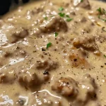 ['A close-up view of Healthy Sausage Gravy in a bowl, showcasing its rich texture and golden hue.', 'Side angle of a creamy Healthy Sausage Gravy with cooked ground chicken and spices visible.', 'A detailed shot of Healthy Sausage Gravy, highlighting its savory ingredients and creamy consistency.', 'A vibrant image of Healthy Sausage Gravy, featuring a mix of ground chicken and spices, perfect for breakfast.']