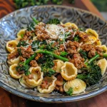 ['A close-up view of a bowl filled with orecchiette pasta, sausage, and broccolini.', 'Side view of a delicious One Pot Orecchiette dish, highlighting the sausage and vegetable mix.', 'Juicy orecchiette pasta with Italian sausage and broccolini displayed in a rustic bowl.', 'A vibrant serving of One Pot Orecchiette with sausage and broccolini captured in natural lighting.']