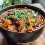 ['Close-up view of a bowl of Sweet Potato Chili with visible sweet potatoes and ground turkey.', 'Side view of a vibrant Sweet Potato Chili showcasing chunks of sweet potato and beans.', 'Juicy Sweet Potato Chili in a bowl, highlighting its colorful ingredients like tomatoes and corn.', 'Detailed shot of Sweet Potato Chili, featuring garnishes like cilantro and shredded cheese.']