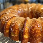 Close-up side view of a moist Apple Cider Donut Cake with a golden brown crust.