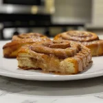 Close-up view of fluffy Pumpkin Spice Protein Cinnamon Rolls with a glistening icing drizzle.