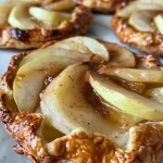 Close-up of a spiced pear galette with golden crust and juicy pear slices.