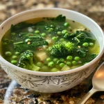 A close-up view of a bowl of Detox Soup, showcasing vibrant green broccoli and spinach.